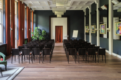 Modern room with rows of chairs and artworks on the walls.