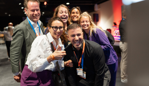 Image of participants smiling at camera at ONE conference business event
