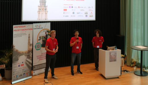 Three speakers in red shirts presenting at a hackathon.
