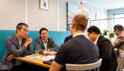 Group of men at a table, engaged in discussion.