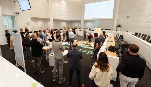 People in a large meeting room in The Hague.