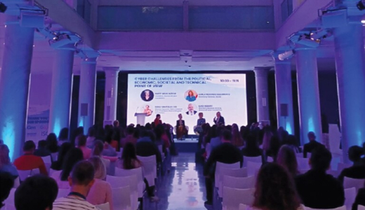 A panel discussion with a speaker and audience in a hall.