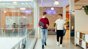Twee mannen in casual kleding wandelen door een kantoor.