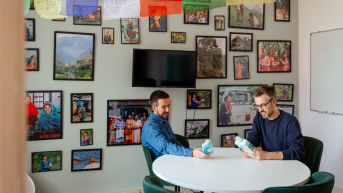 Twee mannen bekijken flessen in een decoratieve kamer