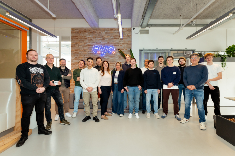 Een diverse groep mensen staat samen in een kantoor.