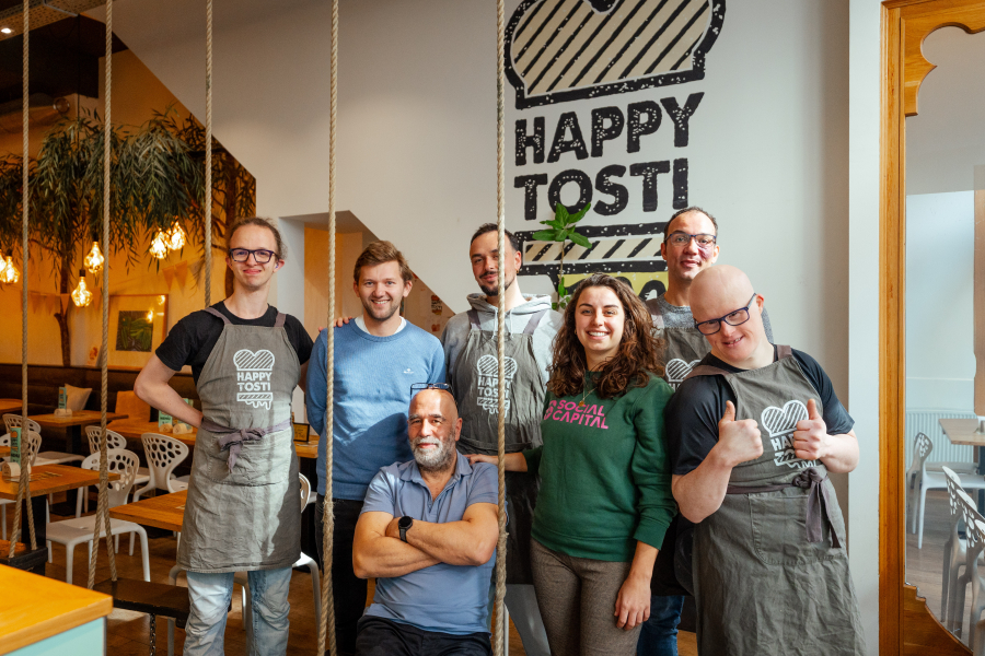 Zeven medewerkers van Happy Tosti poseren samen.