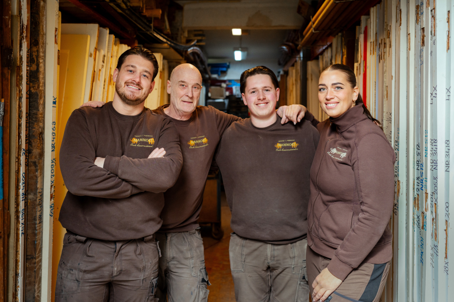 Vijf teamleden van Mammoth staan glimlachend in het atelier.