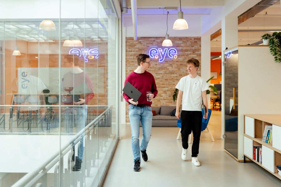 Twee mannen in casual kleding wandelen door een kantoor.