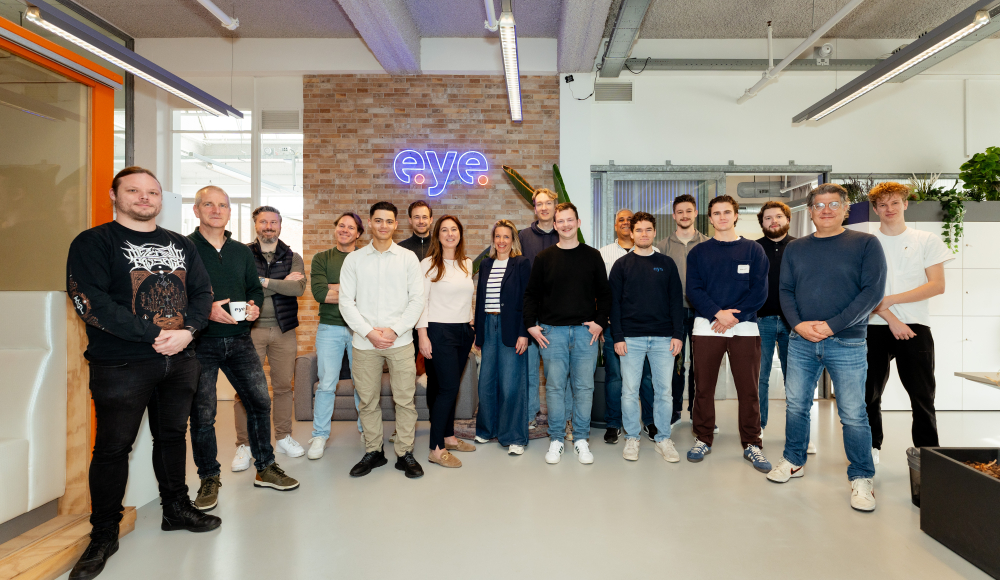 Een diverse groep mensen staat samen in een kantoor.