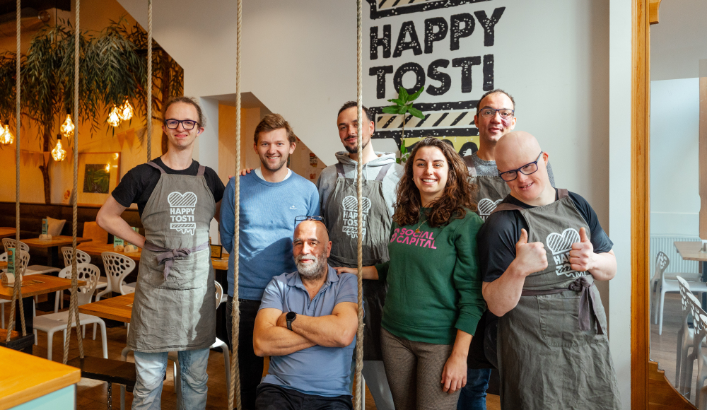 Zeven medewerkers van Happy Tosti poseren samen.