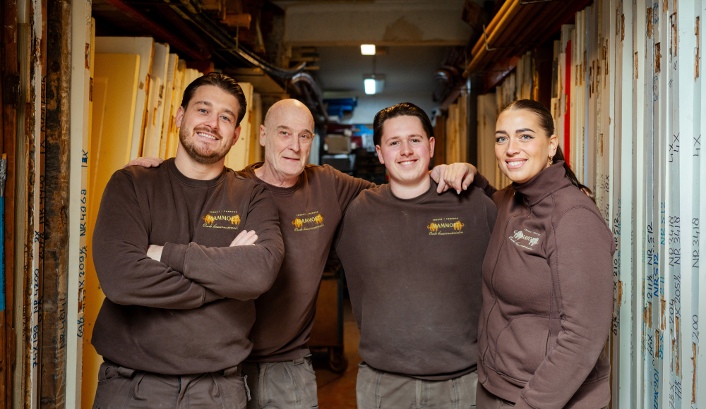 Vijf teamleden van Mammoth staan glimlachend in het atelier.