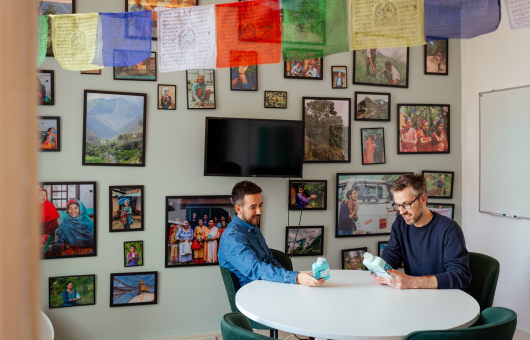 Twee mannen bekijken flessen in een decoratieve kamer