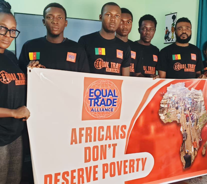 Seven people in black shirts holding a poster reading 'Africans don’t deserve poverty'.