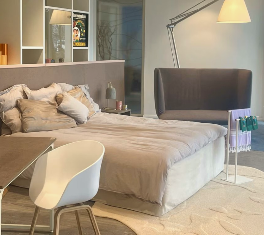Bedroom hotel room with bed, desk, and plant with products made out of seaweed