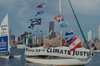 A sailing boat with flags, participants advocating for climate justice.