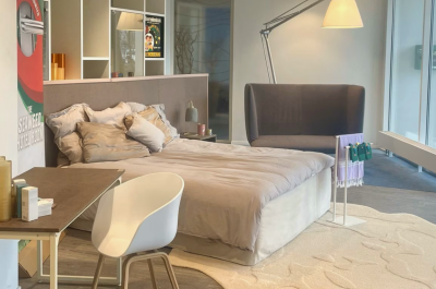 Bedroom hotel room with bed, desk, and plant with products made out of seaweed