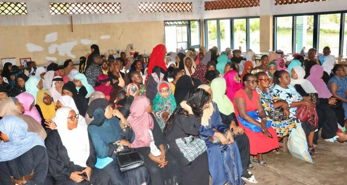 Women in colorful attire sitting during a gathering.