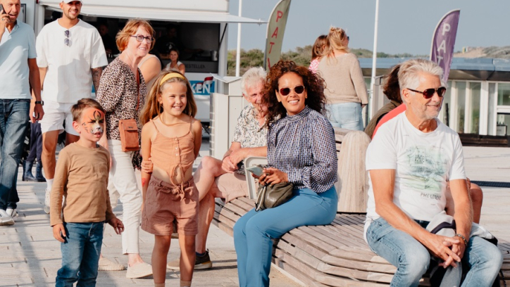 Group of people enjoying the pier, sunny day.
