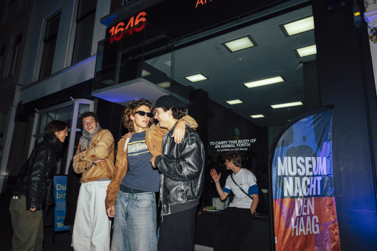 Group of young people posing outside an exhibition space.