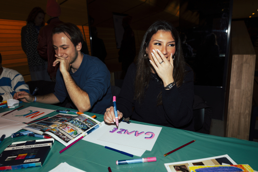 Two people engaging in a creative activity, laughing and drawing.