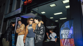 Group of young people posing outside an exhibition space.