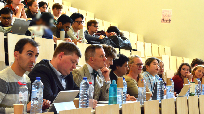 A group of people attentively listening to a presentation.