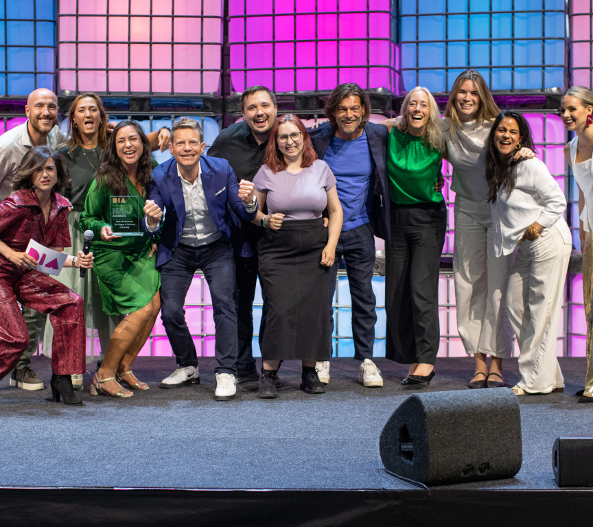 Group of people posing with an award on stage
