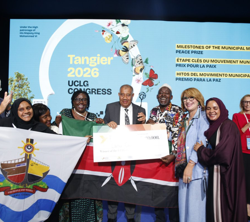 Group of people posing with flags and an award during the UCLG Congress.