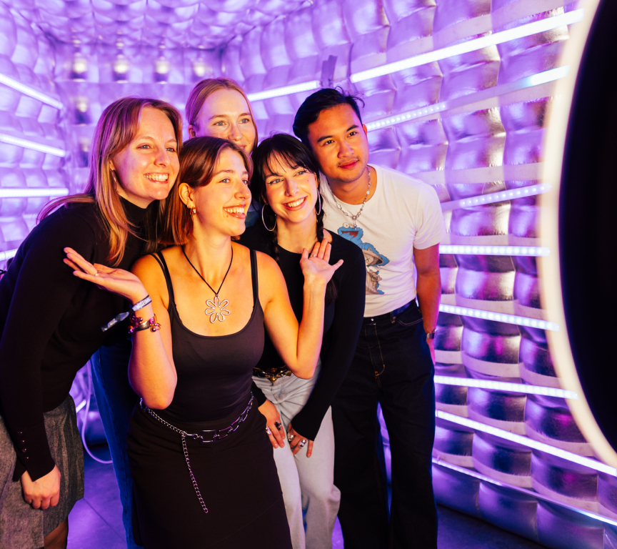 Group of five young people smiling and posing