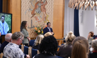 People listen to a speaker in a room with artwork.