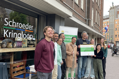 A group of people posing in front of Schroeder Kringloop in The Hague.