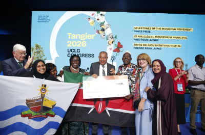 Group of people posing with flags and an award during the UCLG Congress.