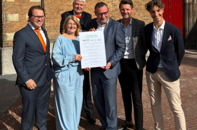 Six people posing with a document in The Hague.