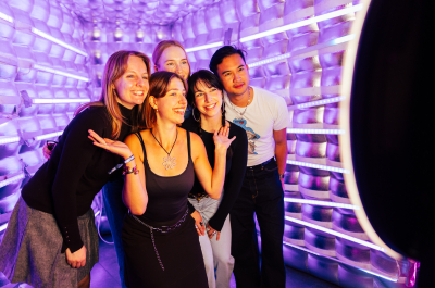 Group of five young people smiling and posing