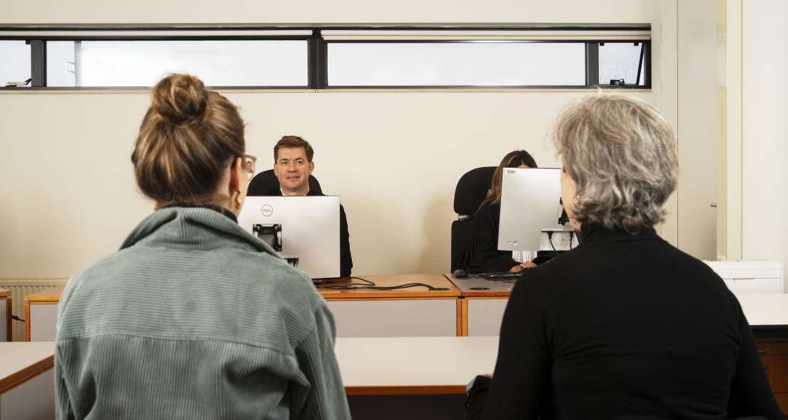 A community judge engages with local residents during a Wijkrechtspraak court session in The Hague Southwest, where accessible and people-centered justice takes place close to home.
