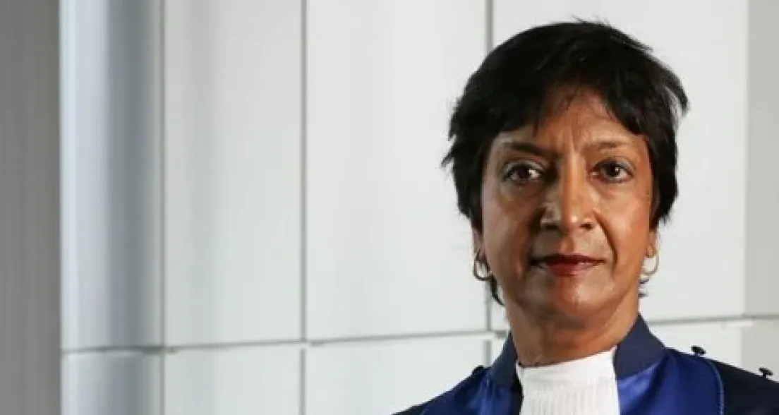 A woman in a blue robe with a white collar.