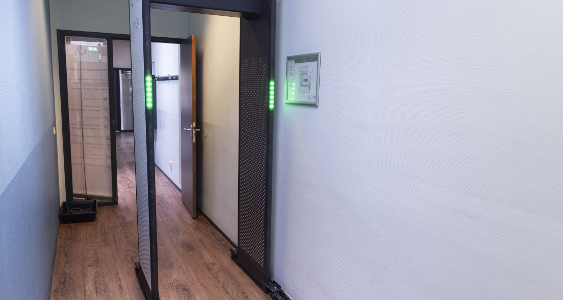 Security screening checkpoint with a walk-through metal detector at the Wijkrechtspraak court location in The Hague Southwest, ensuring safe access to the community courtroom.