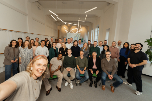 A group photo of a team in an office setting.