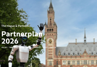 Een robot met een hand omhoog voor het Binnenhof in Den Haag.