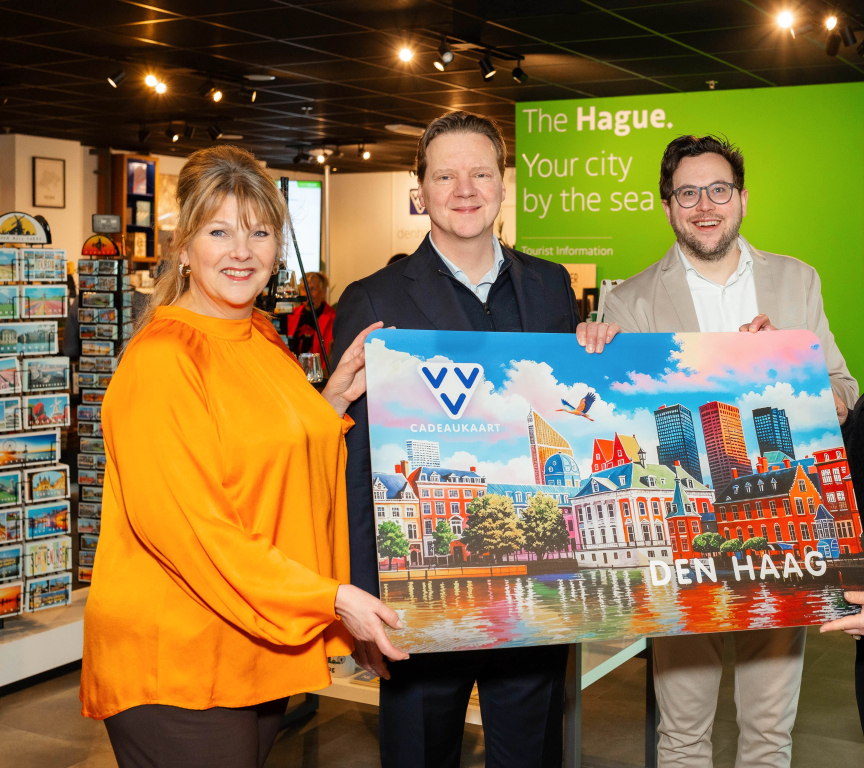 Vier mensen tonen een cadeaukaart van Den Haag.