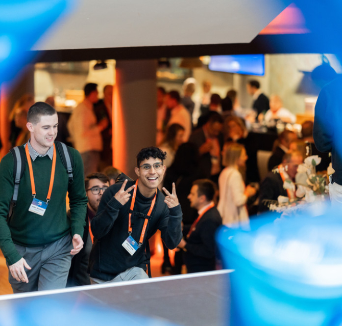 Twee jongeren glimlachen en poseren op een evenement.