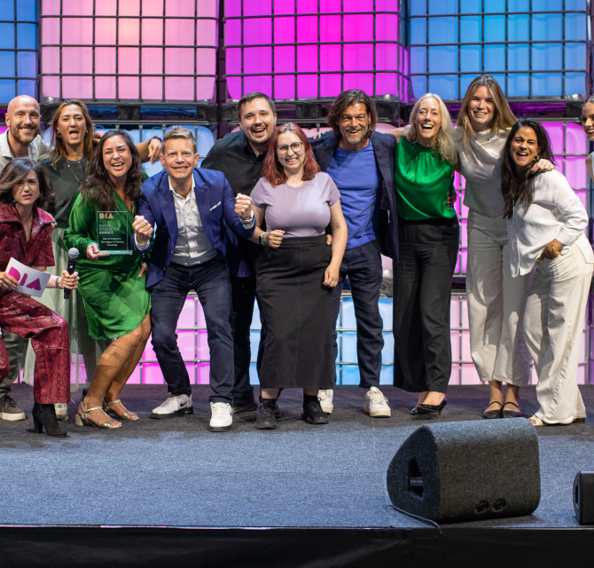 Group of people posing with an award on stage