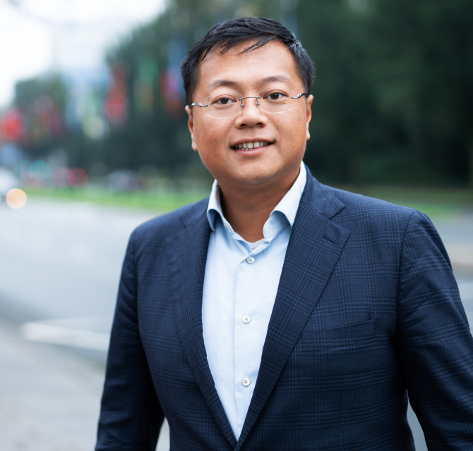 Een man in een blauw pak, staand op straat in Den Haag.