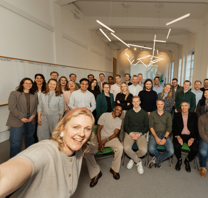 A group photo of a team in an office setting.