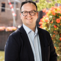 A man in a blazer poses by the Hofvijver.