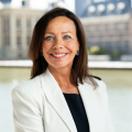 Woman in a white blazer smiles by the Hofvijver.