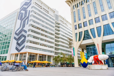 A modern building with outdoor seating and artworks.