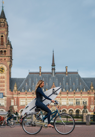 Surfer op de fiets voor het Vredespaleis